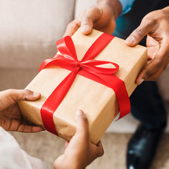 Little girl taking dad's gift box, closeup
