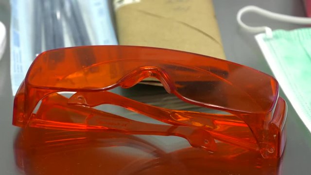 Dentist's tools are on the table. Goggles for dentists - use with photopolymerization lamps.  Dentist clinic. protective glasses. Dental goggles, equipment 
