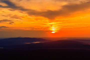 sunset in the clouds above the distant hills