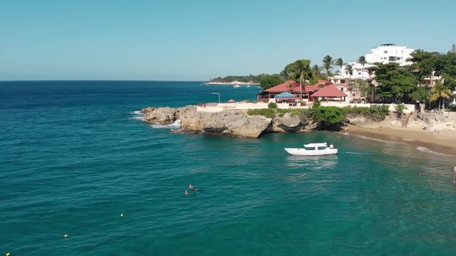 Flight over the ocean coast rifs and hotels and people on vacation, the yacht sails from the shore