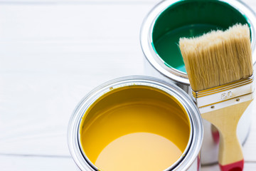House renovation concept, colorfull paint cans and paintbrushes on wooden background