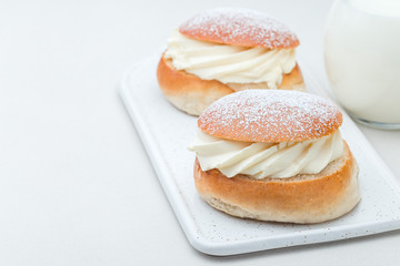 Traditional swedish dessert Semla, also called Shrove bun, with almond paste and whipped cream filling, horizontal, copy space