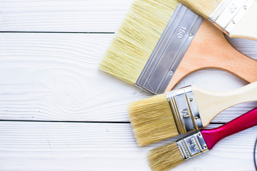 House renovation concept, colorfull paintbrushes on wooden background