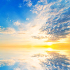 Sky blue and orange light of the sun through the clouds in the sky