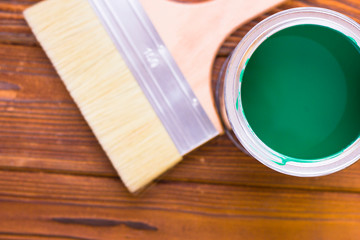 House renovation concept, colorfull paint cans and paintbrushes on dark wooden background