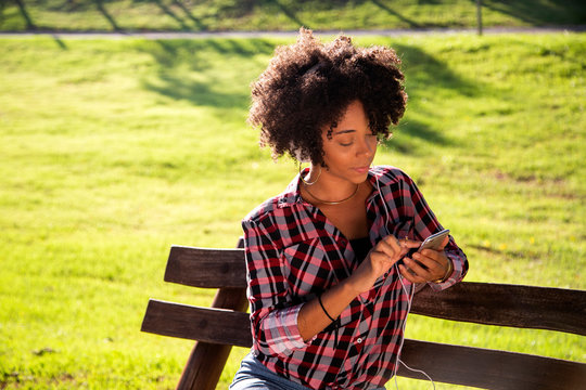Portrait of a young african american woman listening to music on cell phone - Imagem