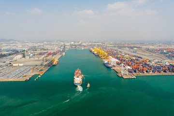 Fototapeta premium Aerial view. Container ship in pier with crane bridge carries out export and import business in the open sea. Logistics and transportation