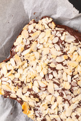 Fresh baked Homemade organic fudge brownies almond slice on black slate stone with copy space