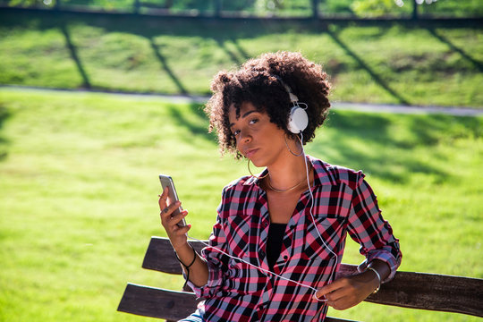 Portrait of a young african american woman listening to music on cell phone - Imagem