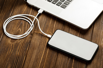 A USB cable connects your phone and laptop