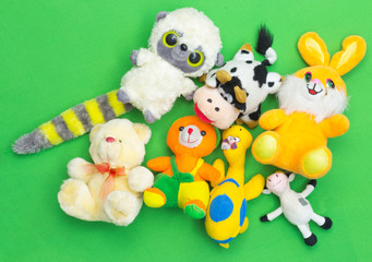 many different, soft animal toys on a green background