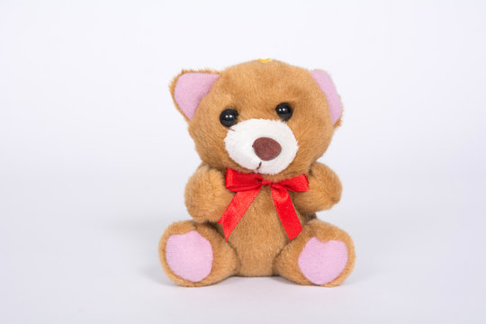 Soft toy bear with a red bow on a white background