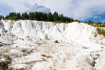 Fototapeta na wymiar Extraction of talc in career. Abandoned white quarry in forest.