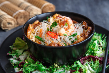 Asian salad with rice noodles with shrimps and vegetables closeup.