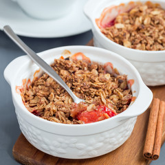 Plum crumble pie or plum crisp with oats and spices, in baking dish, square format