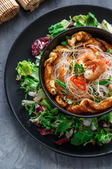 Asian salad with rice noodles with shrimps and vegetables closeup.