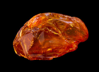 Natural piece of natural amber on black background