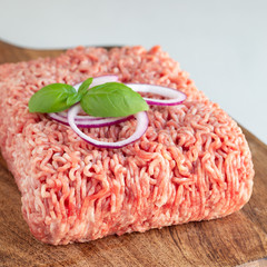 Minced meat from pork and beef. Ground meat with ingredients for cooking on wooden board, square...