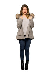 A full-length shot of a Teenager girl with coat with surprise facial expression on isolated white background