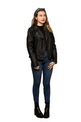 A full-length shot of a Teenager girl with leather jacket is a little bit nervous and scared pressing the teeth on isolated white background