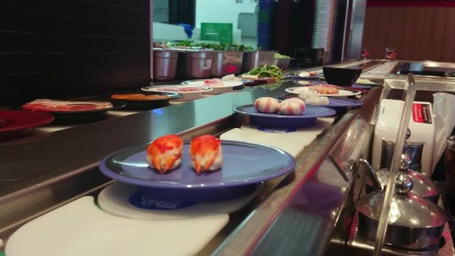 Japanese food belt. Conveyor sushi belt. Row of japanese food buffet dishes in belt.
