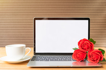Fototapeta premium Red rose and coffee cup with laptop mockup on wood