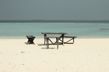 Picnic tables and bench on the shore of a desert island (Ari Atoll, maldives)