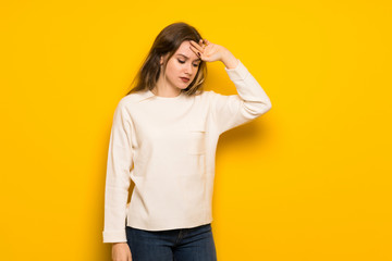 Teenager girl over yellow wall with tired and sick expression