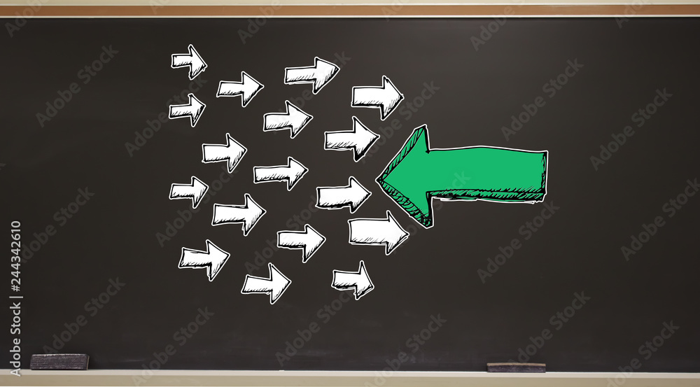 Poster arrow facing in a opposite direction on a blackboard with erasers