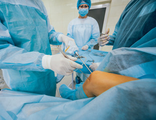 Arthroscope surgery. Orthopedic surgeons in teamwork in the operating room with modern arthroscopic...