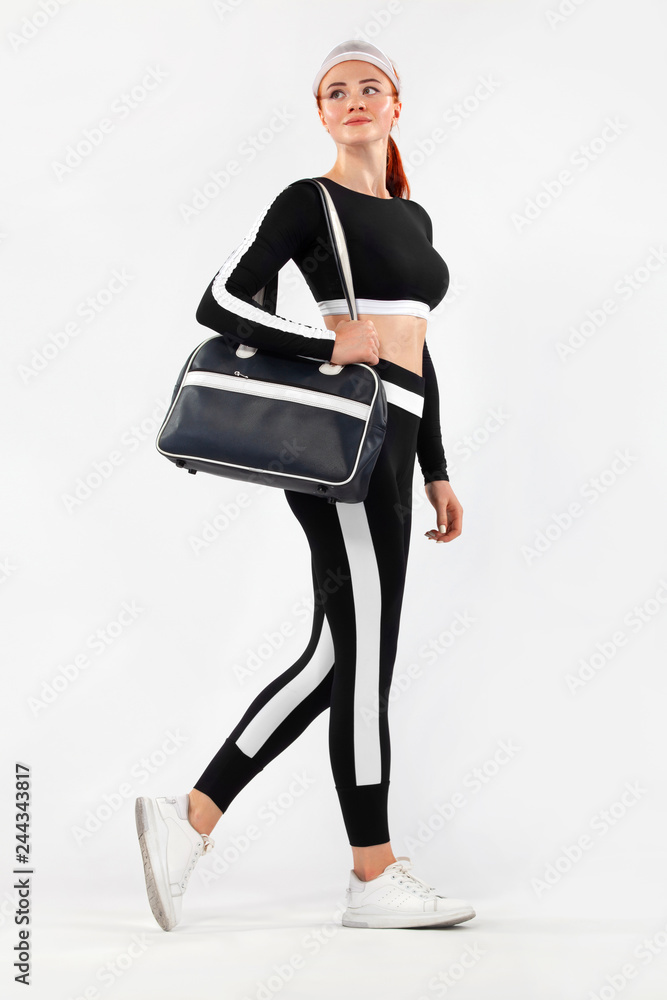 Wall mural Black friday for fitness sale. Sporty fit woman with bag go to training, running on white background. Dynamic movement. Sports and healthy lifestyle.