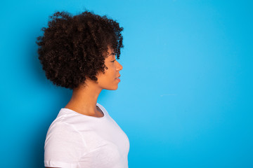 Portrait of cool young black woman laughing against blue wall - Imagem
