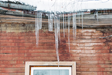 Icicles hanging from the roof of an old wooden building