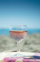Beach party with sea view, romantic celebration on sunny sandy beach, one glass with rose wine