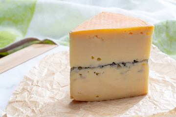French semi-soft cow milk cheese morbier from Franche-Comte region with thin black layer and strong aroma