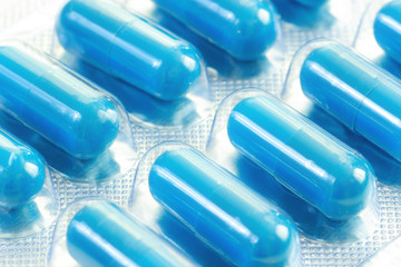 Blue medical pills capsules in foil blister pack macro