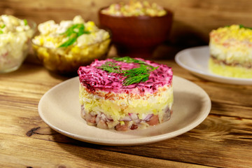 Set of festive mayonnaise salads on wooden table