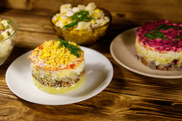 Set of festive mayonnaise salads on wooden table