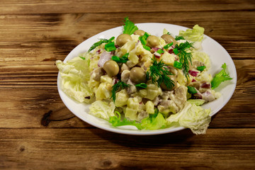 Potato salad with marinated mushrooms, eggs, red onion and mayonnaise on wooden table