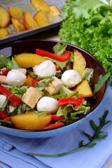Salad with chicken, roasted potato, mozzarella cheese and red pepper in a bowl