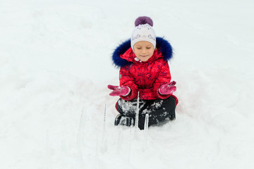 a girl plays in the snow in winter with an icicle of ice