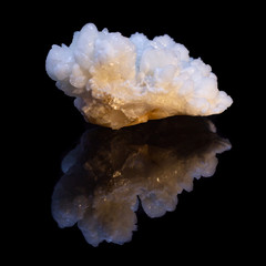 Natural druse of white calcite on a black background with reflection