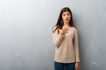 Fototapeta premium Teenager girl with sweater on a vintage wall surprised and shocked while looking right