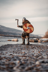 Medieval Scandinavian warrior Viking in full outfit on shore of winter sea
