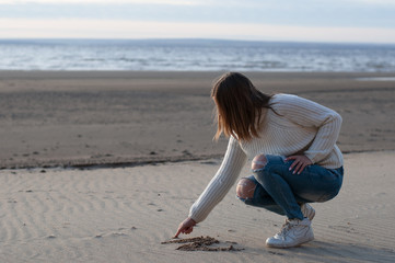 young woman on the beach draws on squeak