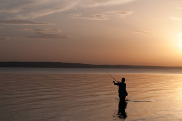 silhouette of man on the beach at sunset, fisherman