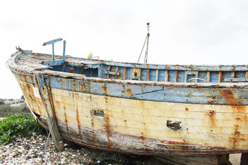 Fototapeta na wymiar old rusted fishing boats abandoned on the land at the atlantic ocean