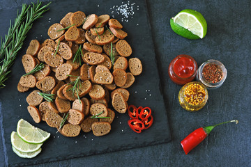 Rye crackers on a stone board with spices and sauce