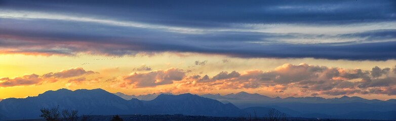 Tranquil panoramia scene of red sun and orange sky sunset over the Rocky Mountains in Colorado by Denver, United States.