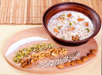 Healthy eating nuts with milk in a clay bowl on a wooden background.